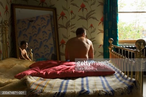http://media.gettyimages.com/photos/young-man-sitting-at-edge-of-bed-reflection-in-mirror-rear-view-picture-id200474871-001?s=170667a
